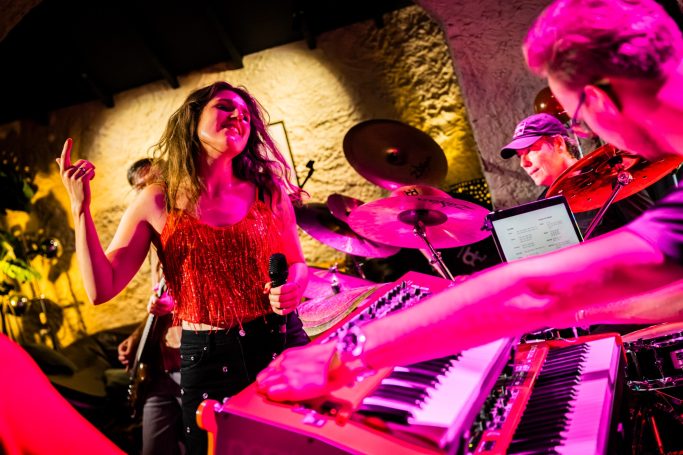 Zangeres performed live met muzikanten, kleurrijke verlichting en een energieke sfeer.
